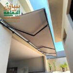 مظلة سيارات كهربائية حديثة بهيكل ألمنيوم وقماش PVC من تنفيذ مؤسسة بنيان اليمامة